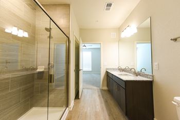 a bathroom with a shower and a sink and a mirror at Pinnacle Apartments, Jacksonville, FL